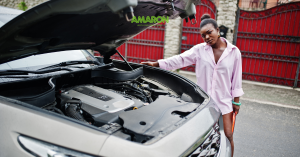 Woman looking over an open car bonet bay